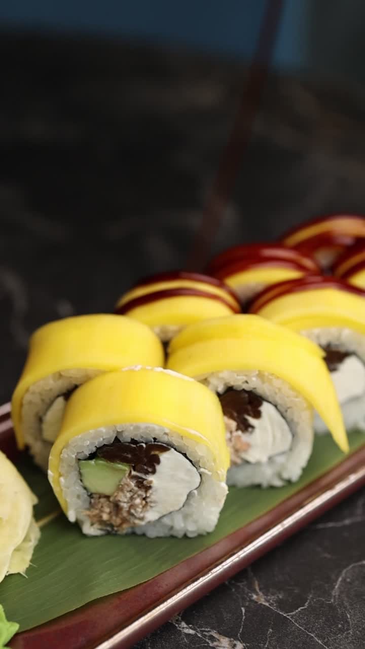Salsa versata a filo su sushi roll al mango su un piatto