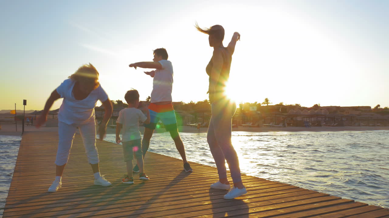 familia haciendo ejercicio en el muelle al atardecer