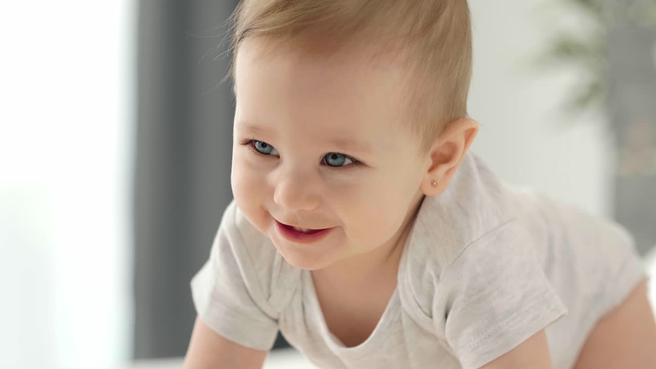 Bedårende jentebaby som krabber på gulvet