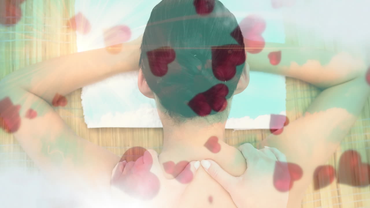 발렌타인 데이에 스파와 빨간 마음에서 마사지를 받으면서 휴식을 취하는 여성