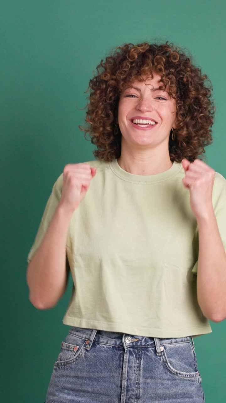 Excited young woman clapping hands and smiling. Vertical orientation