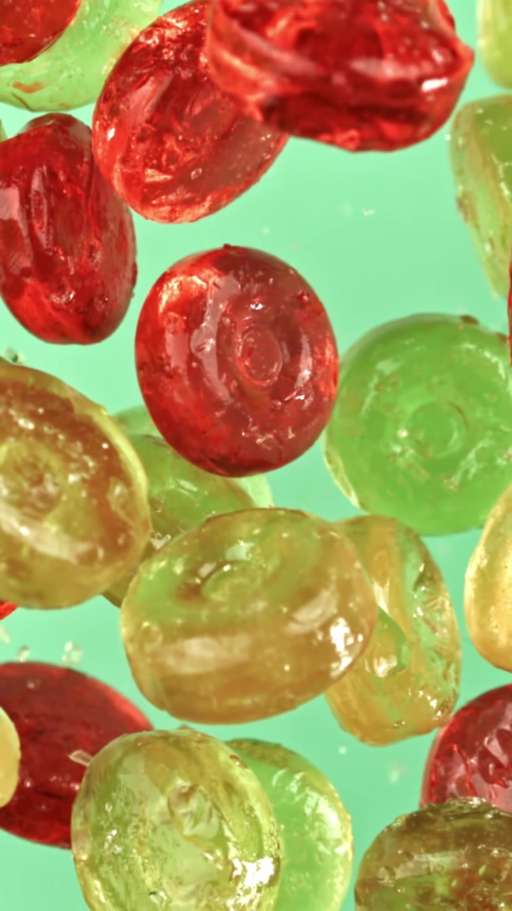 Bunte Bonbons schweben im Wasser mit Blasen