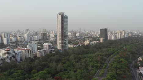 Drohne-Fliegt-über-Den-Mirador-Sur-Park-In-Richtung-Caney-Tower,-Santo-Domingo