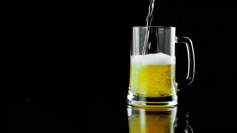 beer poured in beer mug against black background 4k