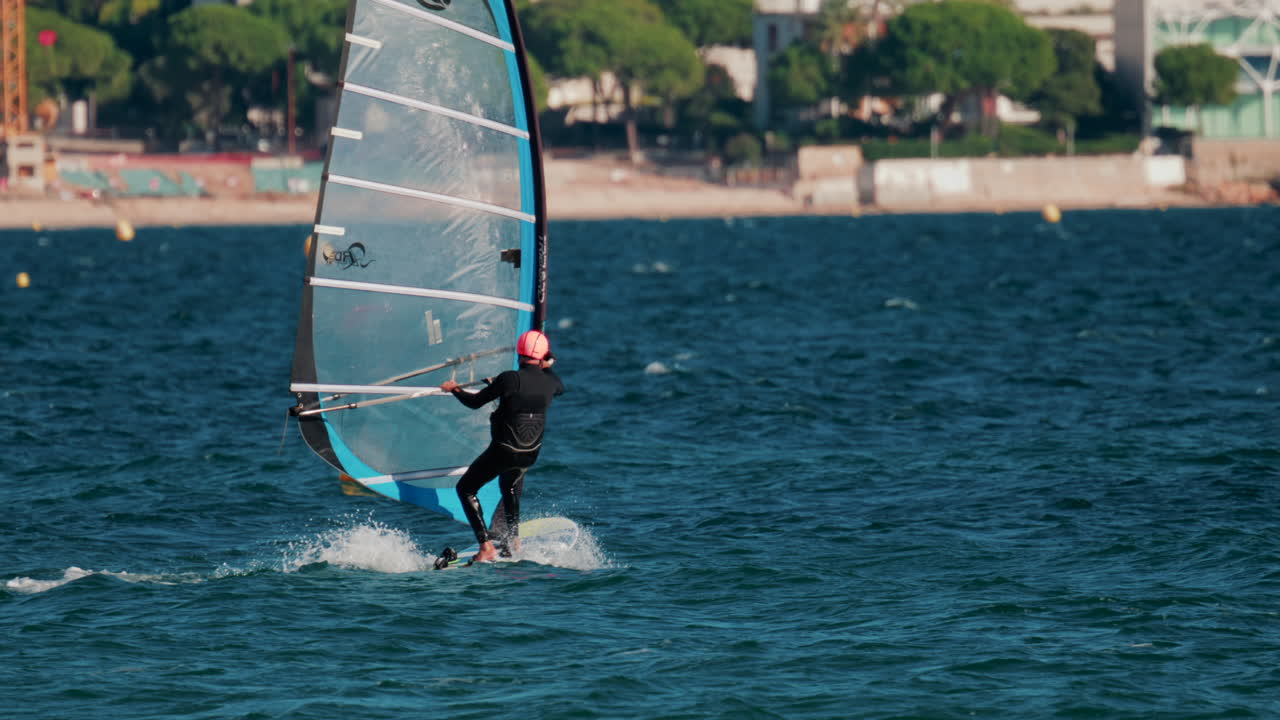 Cannes, France - October 5, 2025: Athlete windsurfing on turquoise sea on a sunny day