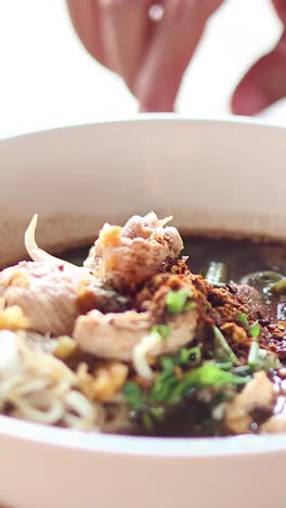 adding final touches to a savory noodle dish