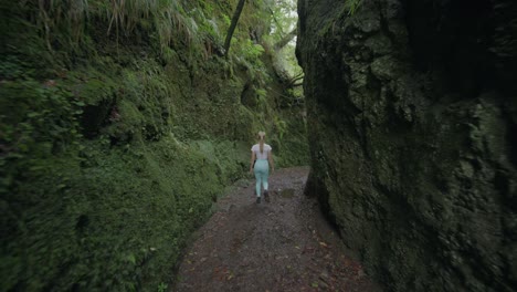 attractive sporty blond woman hiking through balcoes canyon in madeira