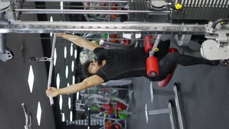 Young-man-exercising-on-lateral-pull-at-gym---concept-of-bodybuilding