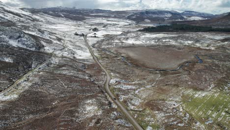 Car-driving-over-a-road-between-mountain-landscape-near-Broadford-at-Isle-of-Skye