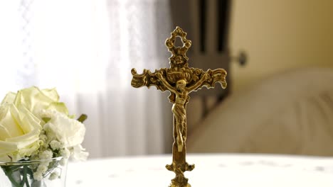 a copper decorative crucifix against the backdrop of a bridal bouquet