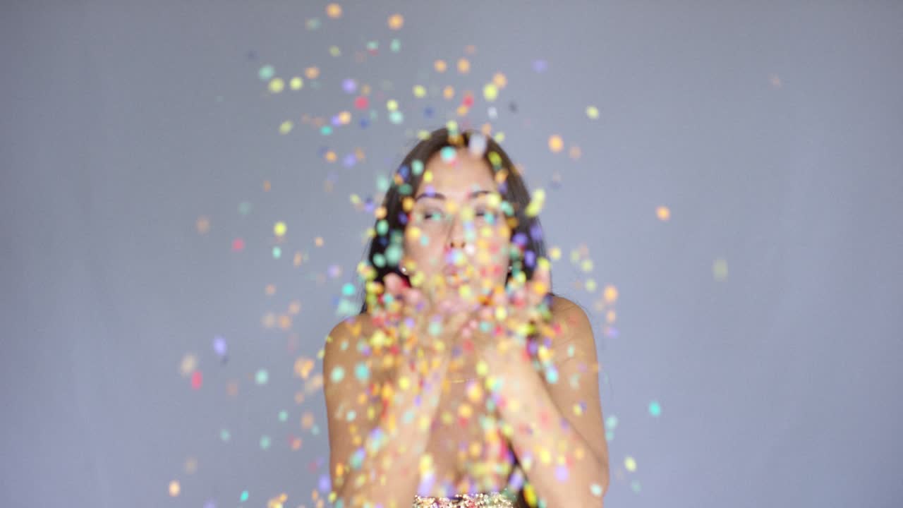 다채로운 새해 콘페티를 불어넣는 젊은 여성