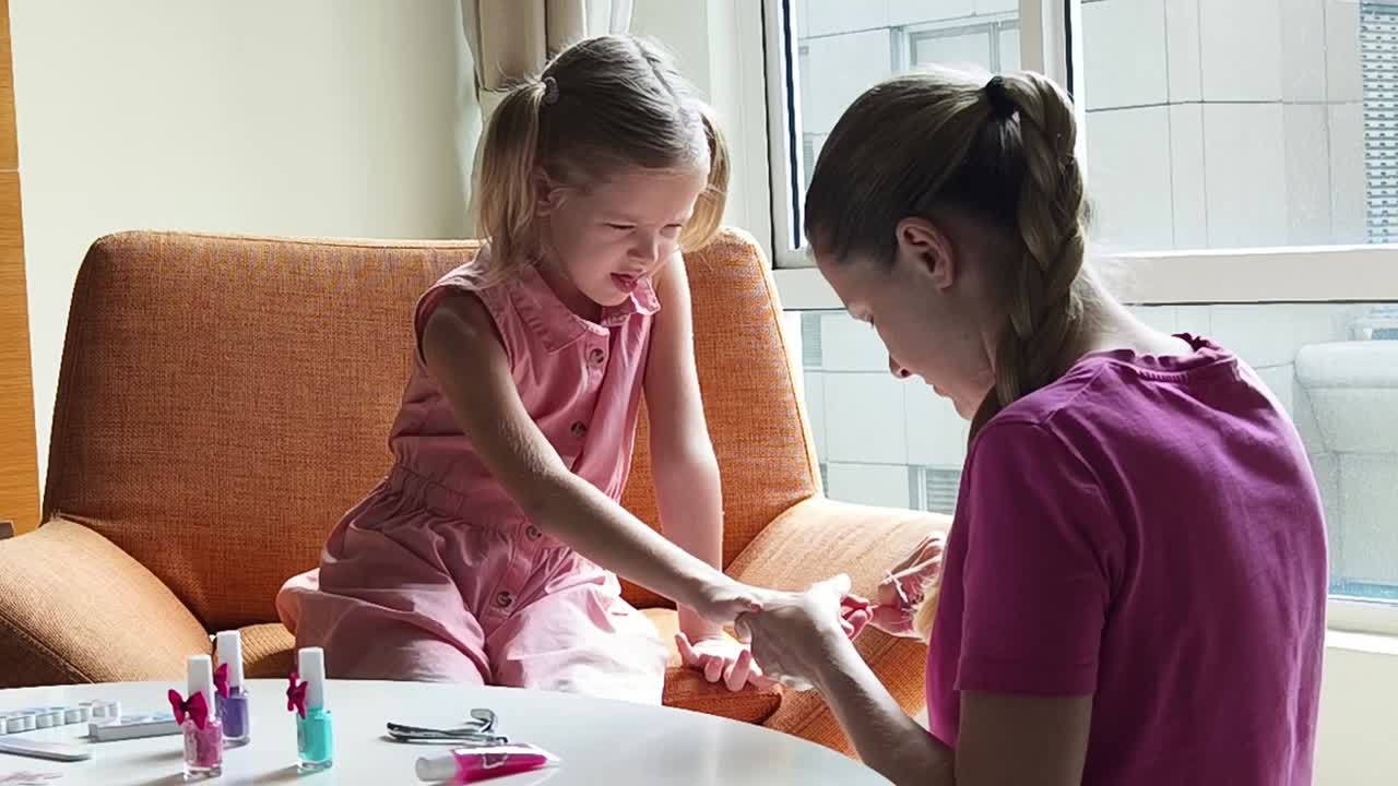 mãe e filha fazendo arte de unhas em casa