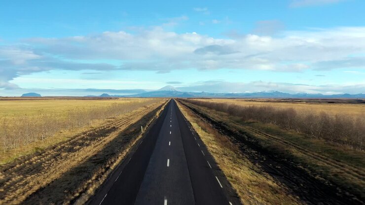 Sorvolo aereo: strada panoramica islandese vuota verso il paesaggio glaciale