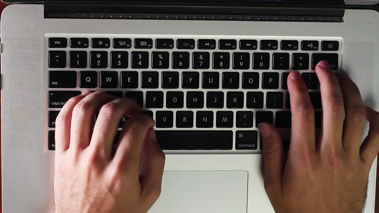 Typing laptop keyboard with two hands overhead
