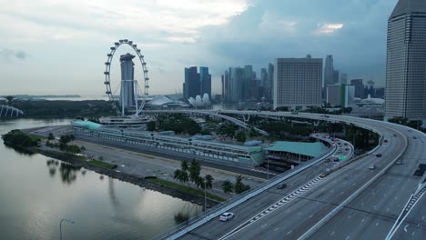 Drone-shot-flying-above-ECP-Bridge-of-Marina-Promenade-and-Singapore-Flyer-Eye,-wide-orbit-of-Formula-1-One-Paddock-Area