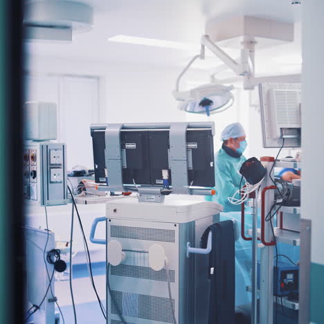 operating room with modern equipment and surgeons in medical uniform. view from the corridor into the cabinet with special outfit for operation in a private clinic inside.