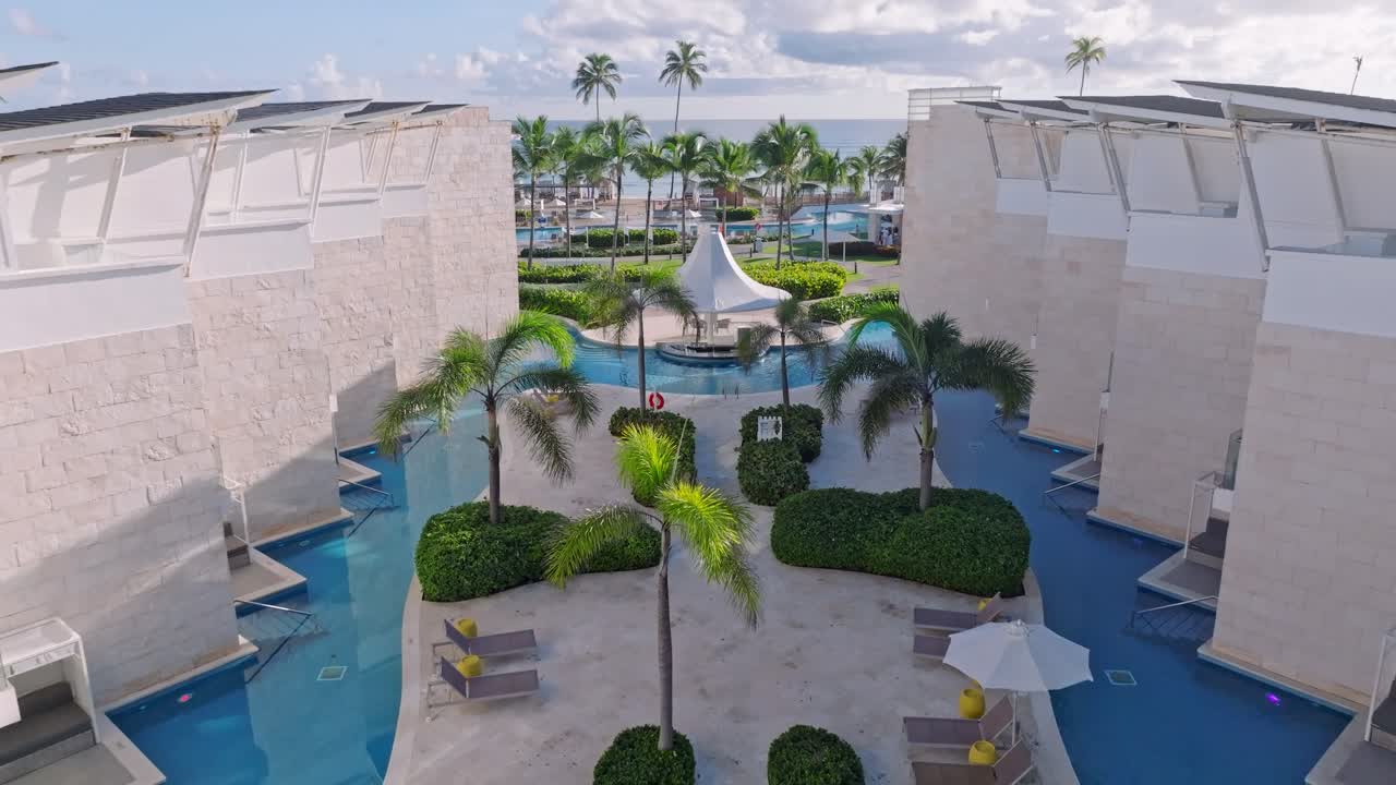 Drone flight over luxury hotel resort with private pool apartments in Punta Cana at sunset time