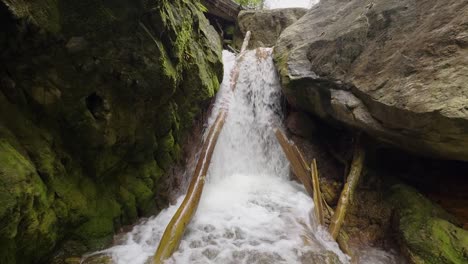 a peaceful waterfall flows over rocks in las golondrinas, honduras, framed by mossy stones and lush greenery. a perfect natural scene for travel, relaxation, and nature projects.