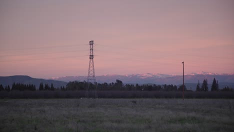 Un-Cielo-Pastel-Sobre-Las-Montañas-De-Sierra-Nevada-Con-Líneas-Eléctricas-Y-árboles,-En-Primer-Plano-En-Clovis,-Ca,-Ee.uu.