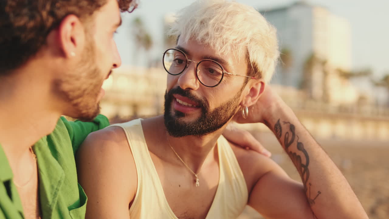 Due giovani uomini che hanno una conversazione intima sulla spiaggia al tramonto