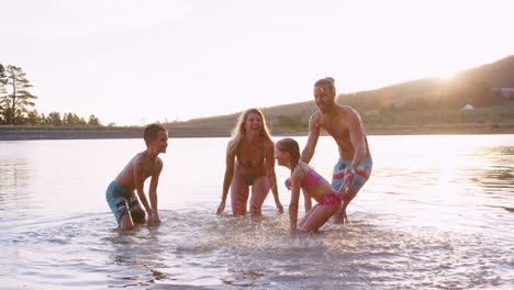 Padres-Con-Niños-Jugando-Y-Chapoteando-En-El-Lago