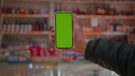 man hand holding the smartphone on green screen chroma key background