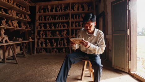 wood carving artisan inspecting a piece