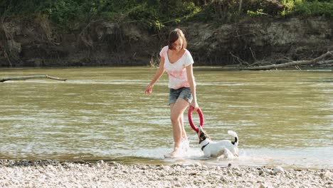 woman playing with dog near river