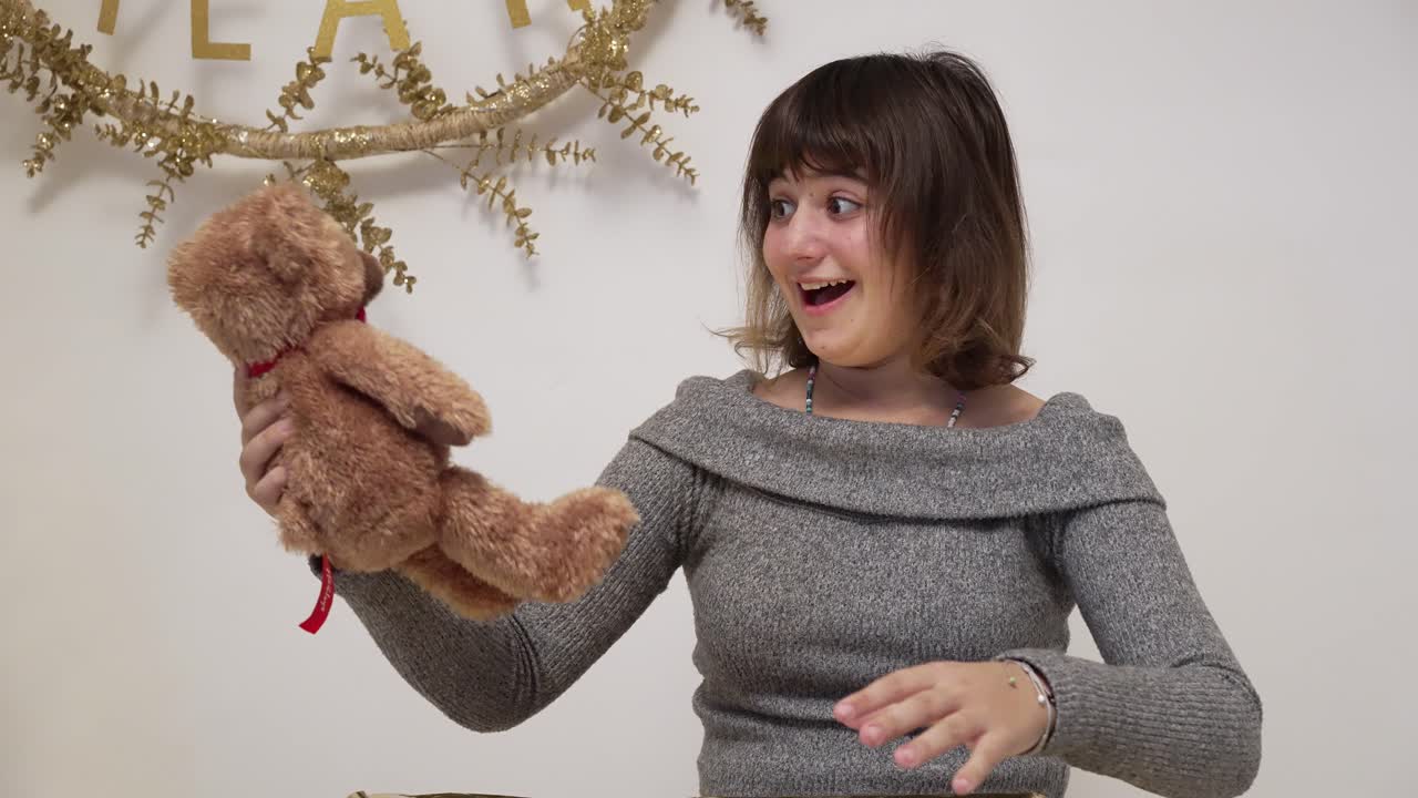 소녀는 크리스마스 선물을 열 때 너무 기뻐한다