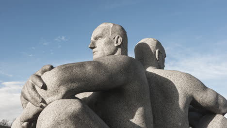 granite statute of two men sitting back to back by gustav vigeland as part of vigeland facility at frogner park, oslo, norway