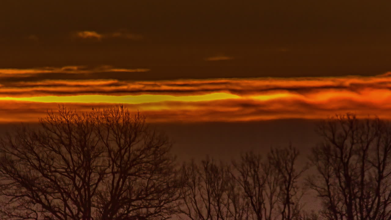 타임스에서 새벽에 구름을 통해 오렌지색 하늘 위에 떠오르는 태양의 가까운 모습