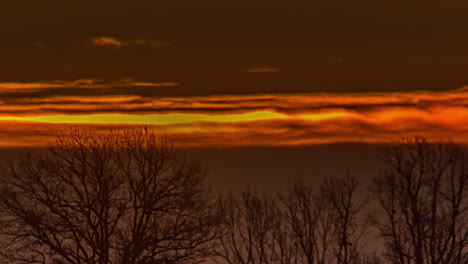 Vista-De-Cerca-Del-Sol-Saliendo-Sobre-El-Cielo-Naranja-A-Través-De-Las-Nubes-Al-Amanecer-En-Timelapse