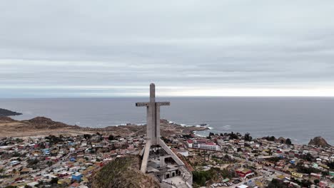 aerial view of a large cross monument on a hillside overlooking the ocean