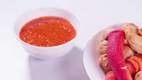 fried meatballs and dipping sauce on a white background