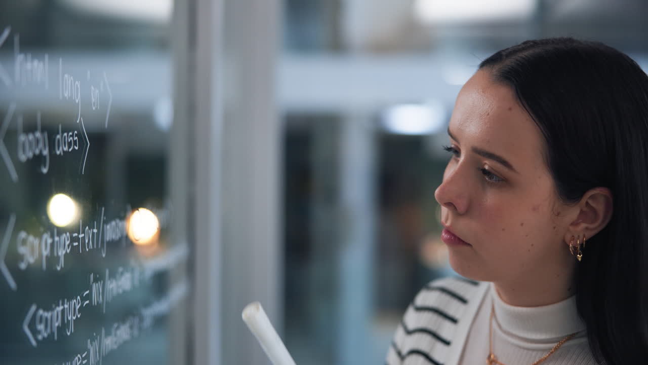 Woman writing code on glass