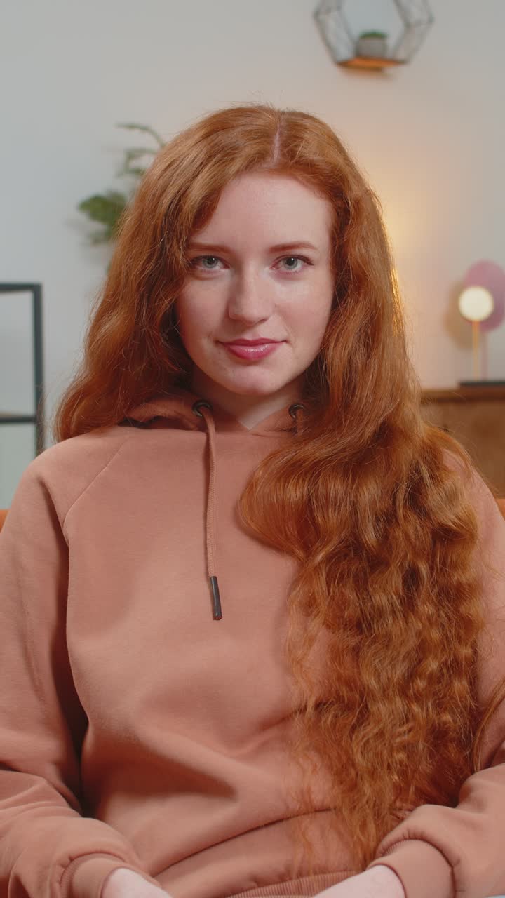 성공한 부유한 젊은 백인 여성은 집에서 소파에 앉아 달러 지폐를 들고 있습니다.