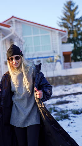 beautiful caucasian woman poses outdoors in winter. model shows fashionable look and accessories. vertical video.
