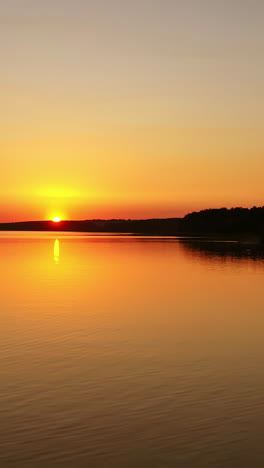 river at sunset. flight over the evening water. natural landscape of a lake at the setting sun. aerial view. vertical video