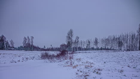 Low-Angle-Aufnahme-Eines-Schneebedeckten-Feldes-Mit-Wolkenbewegung-Nach-Sonnenuntergang-Im-Zeitraffer-Entlang-Der-Ländlichen-Landschaft-Am-Abend