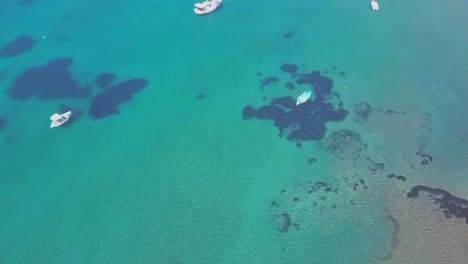 top down aerial view of passenger boats at shallow ocean coast water