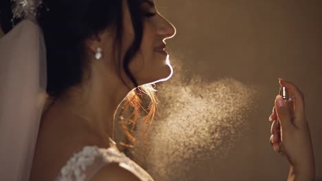 hermosa novia se divide el perfume en sí misma. día de la boda. cámara lenta