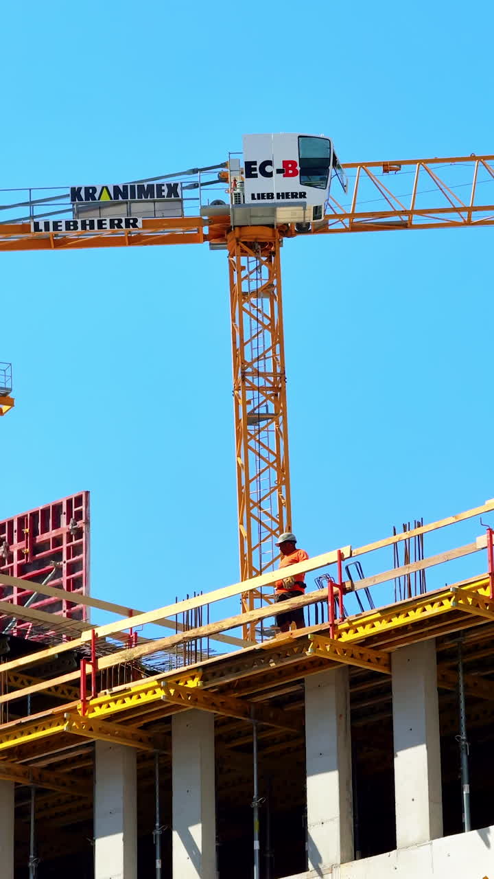 Workers on skyscraper site. Workers are actively constructing a high-rise building using a crane and scaffolding under clear blue skies