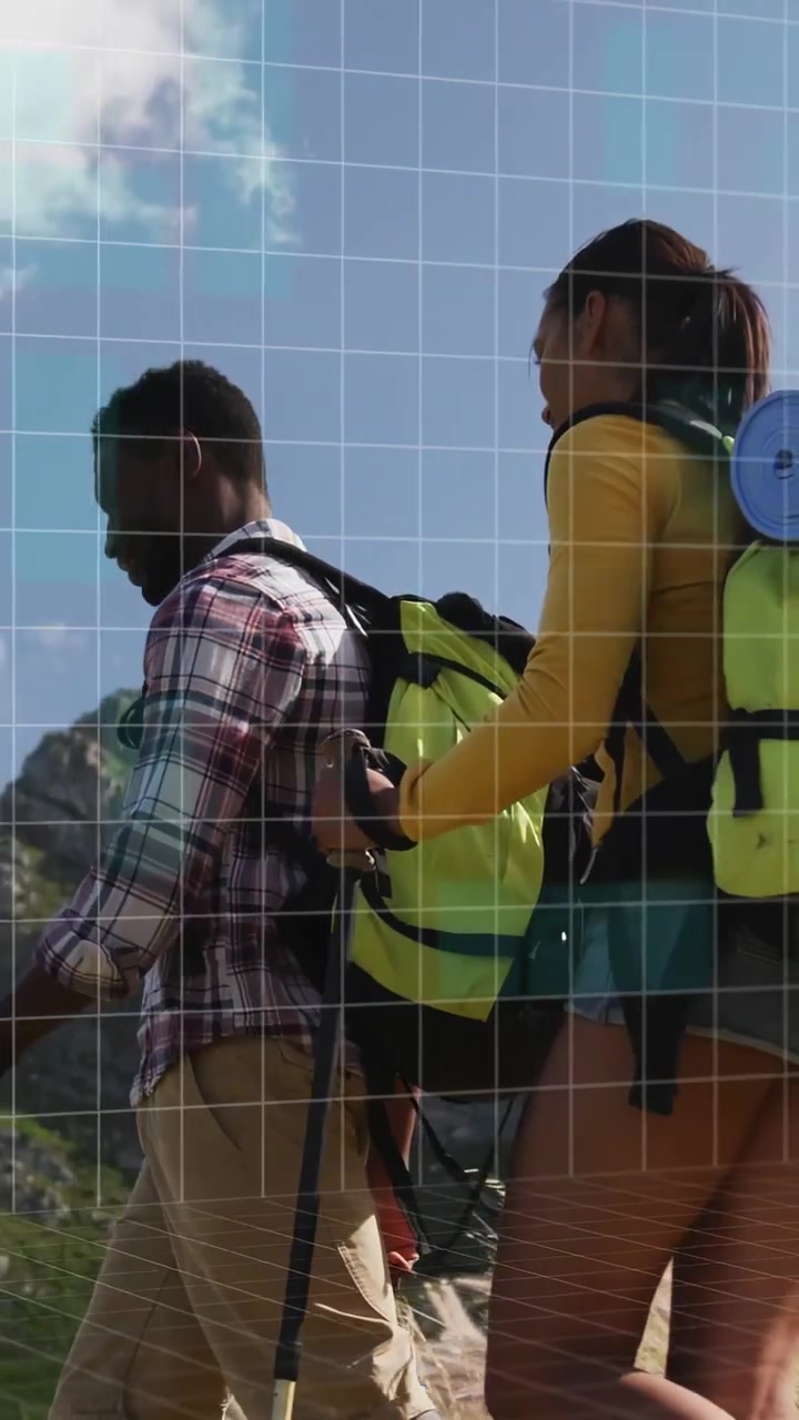 Video verticale: Uomo che precede, donna che stabilizza lo zaino durante un'escursione, con una sovrapposizione tecnologica che mostra il percorso sull'inquadratura.