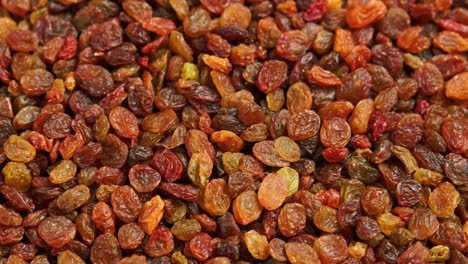 looped spinning full frame background of yellow and brown raisins pile