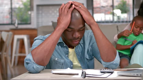 stressed father calculating bills at home