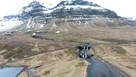 Disparo-De-Drones-Inclinándose-Hacia-Arriba-Del-Lago-De-Islandia-Con-Montañas-En-La-Distancia