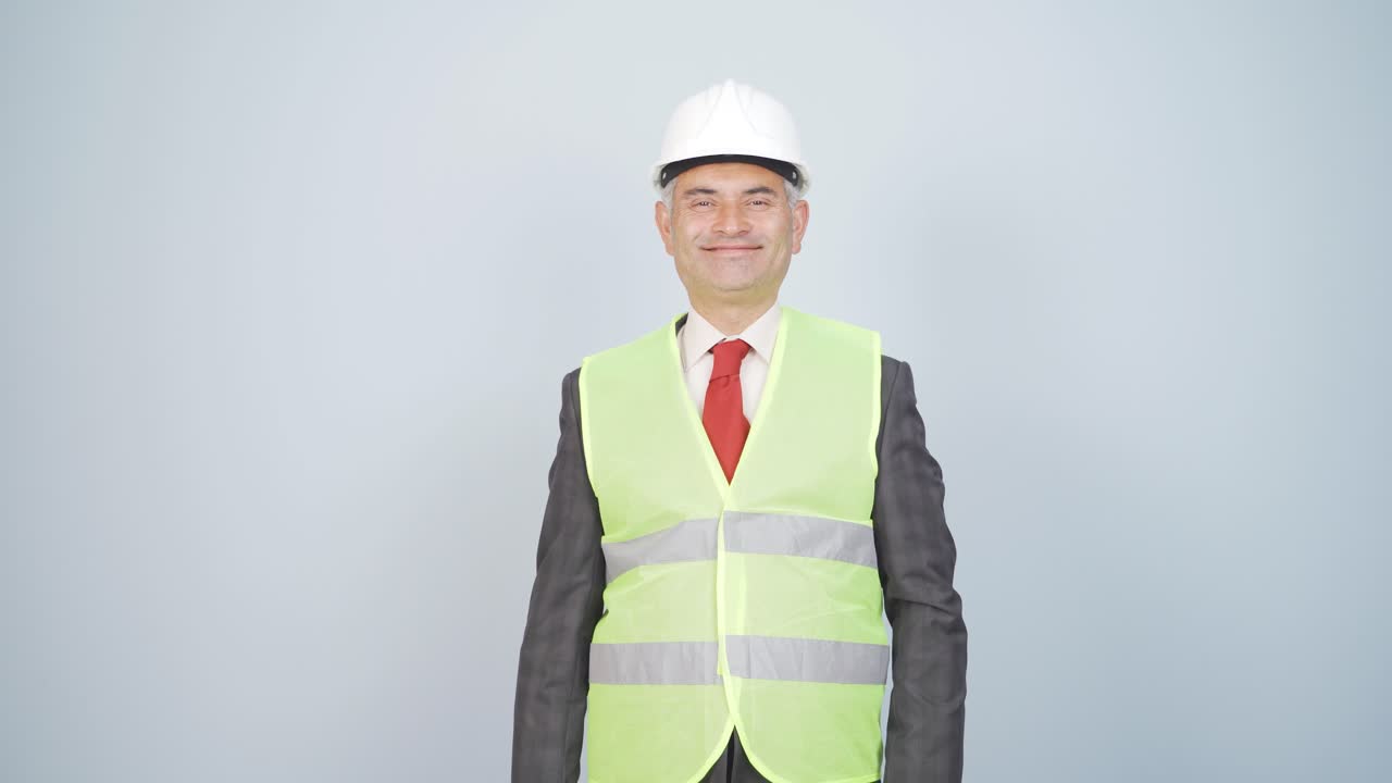 el ingeniero con un casco y sonriendo.