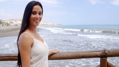 Bella-Dama-En-La-Barandilla-De-La-Playa-Sonriendo-A-La-Cámara