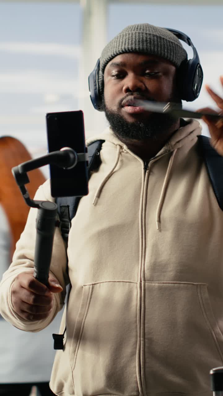 Vertical Video Solo male traveler, recording video blog, in airport terminal lounge