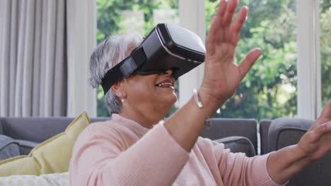 vr 헤드 ⁇ 을 착용하고 집에서 즐거움을 느끼는 행복한 혼합 인종의 노인 여성